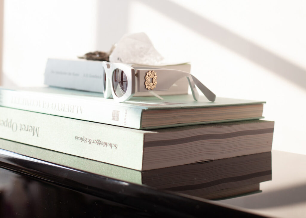 Weisse Sonnenbrille liegt auf einem Bücherstapel